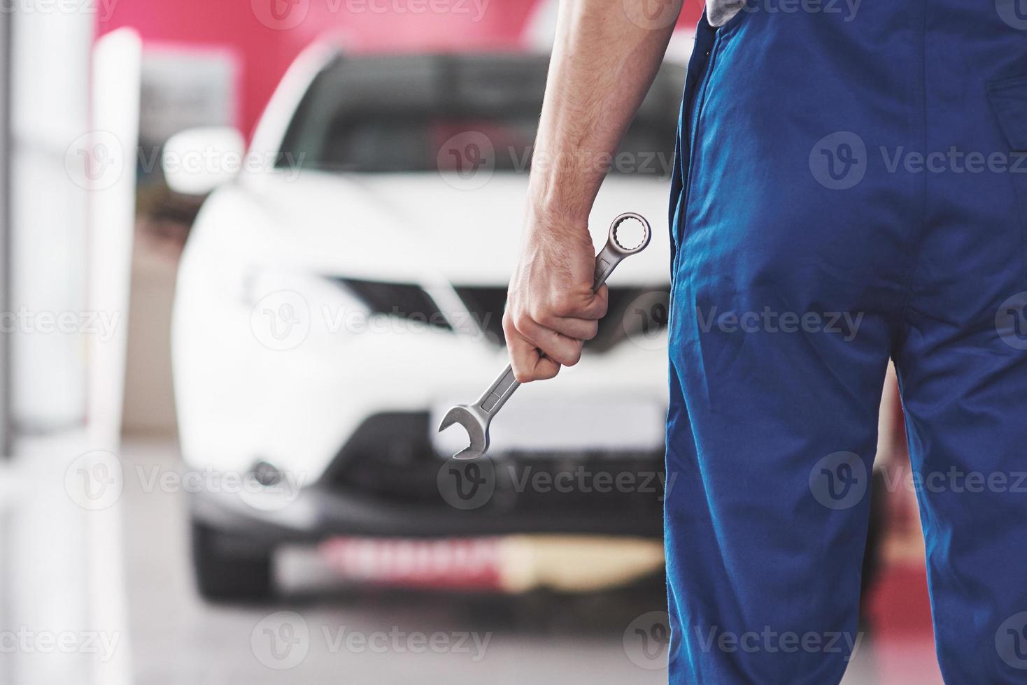 Hand of car mechanic with wrench. Auto repair garage photo