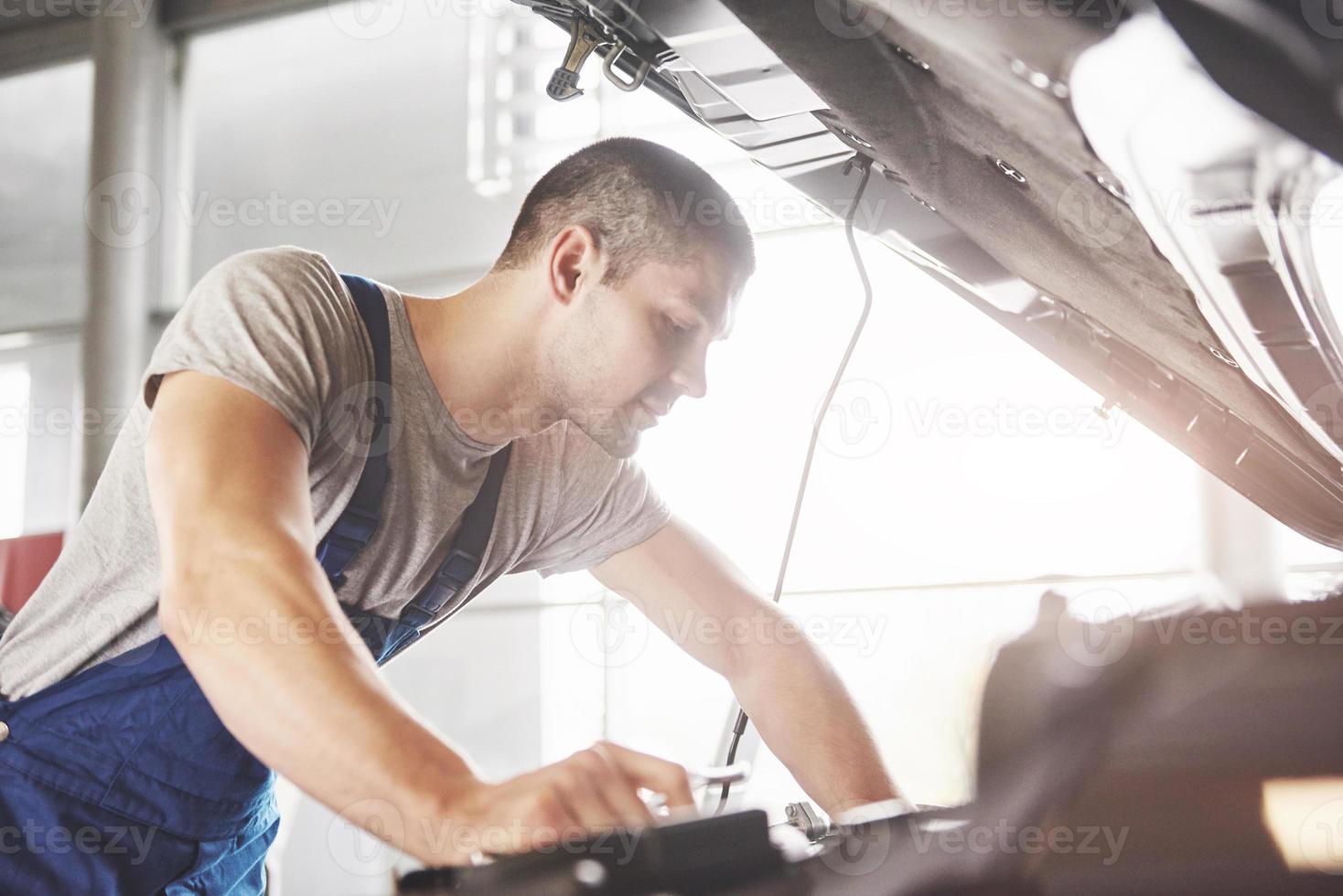Auto mechanic working in garage. Repair service photo