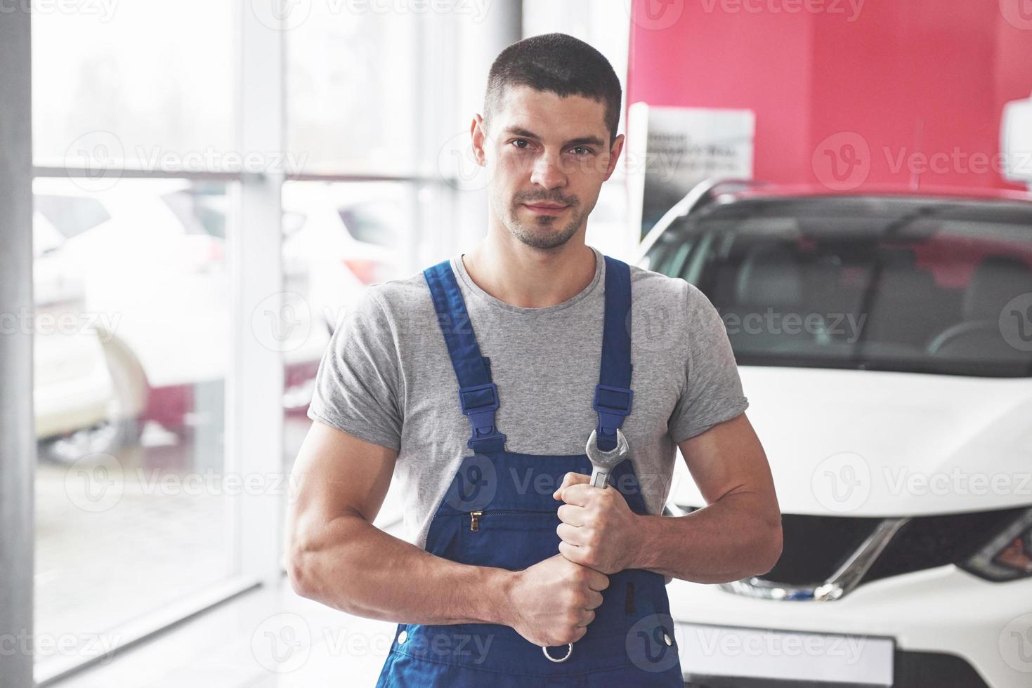 Hand of car mechanic with wrench. Auto repair garage photo