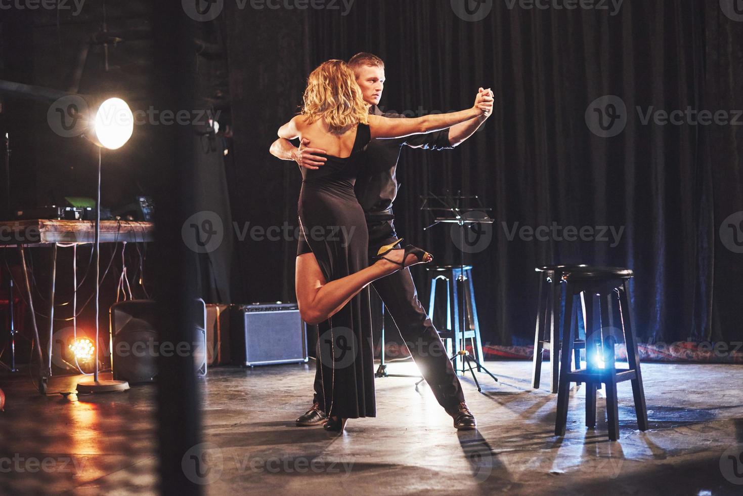 Skillful dancers performing in the dark room under the light photo
