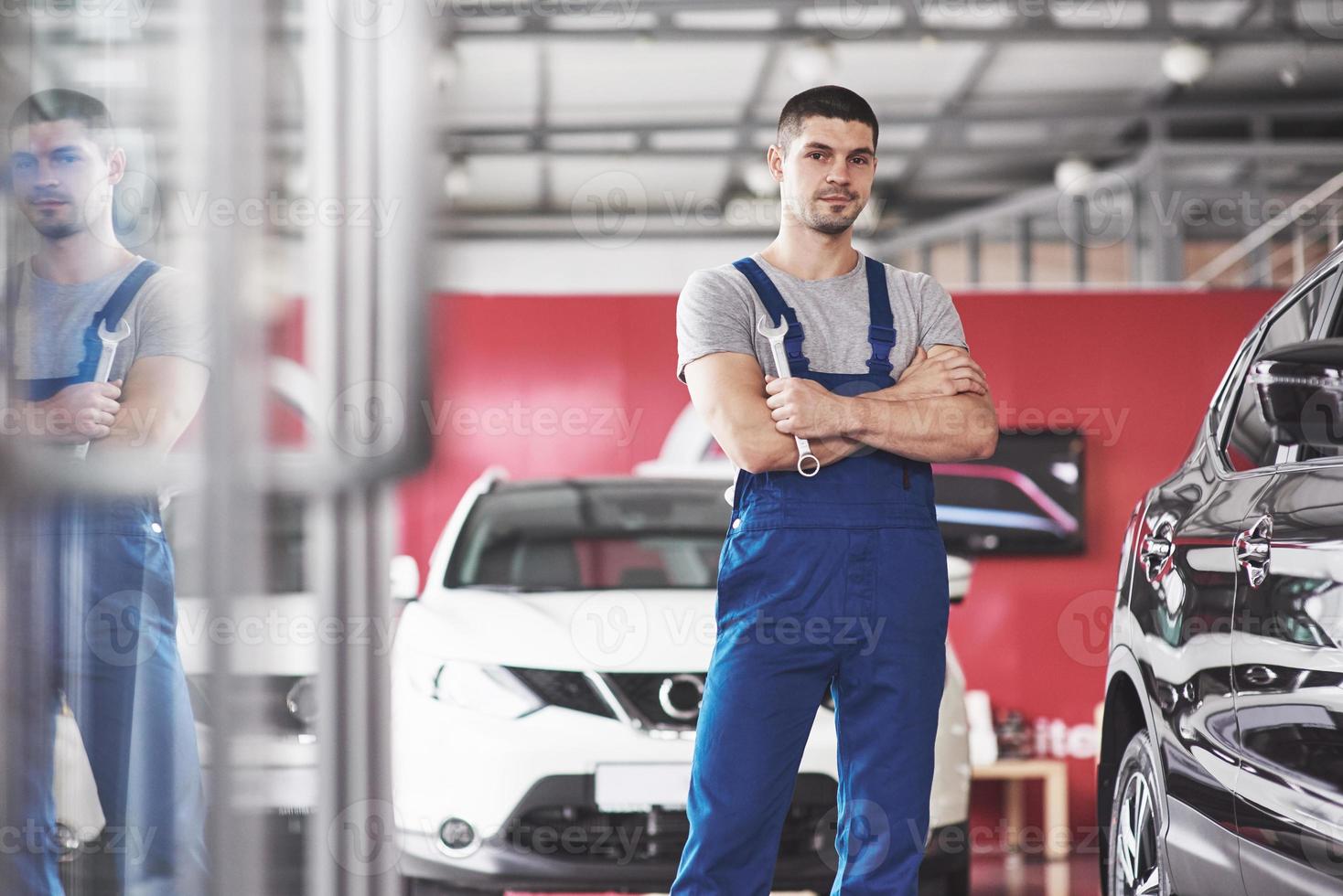 Hand of car mechanic with wrench. Auto repair garage photo