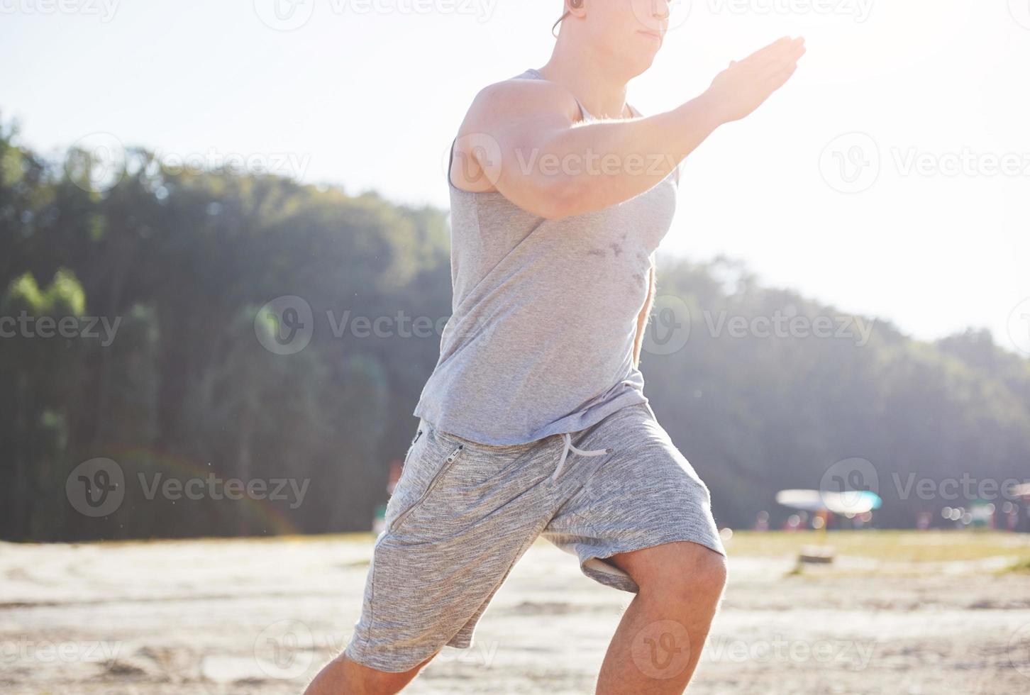 atleta fitness hombre trotando en la naturaleza durante la puesta de sol. persona corriendo ejercitándose viviendo un estilo de vida activo entrenando cardio en verano en ropa deportiva y zapatos. foto