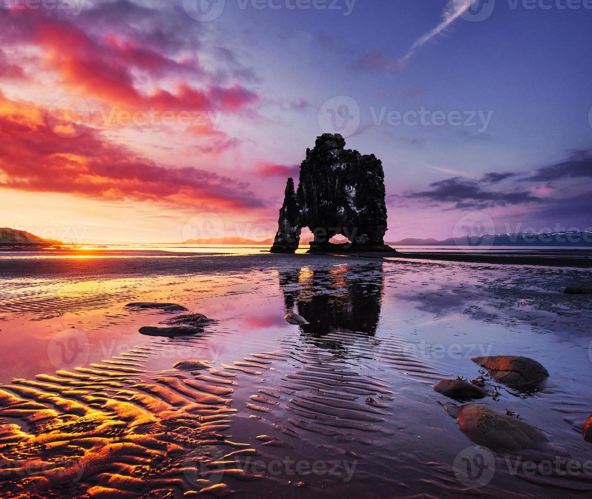 Is a spectacular rock in the sea on the Northern coast of Iceland. Legends say it is a petrified troll. On this photo Hvitserkur reflects in the sea water after the midnight sunset