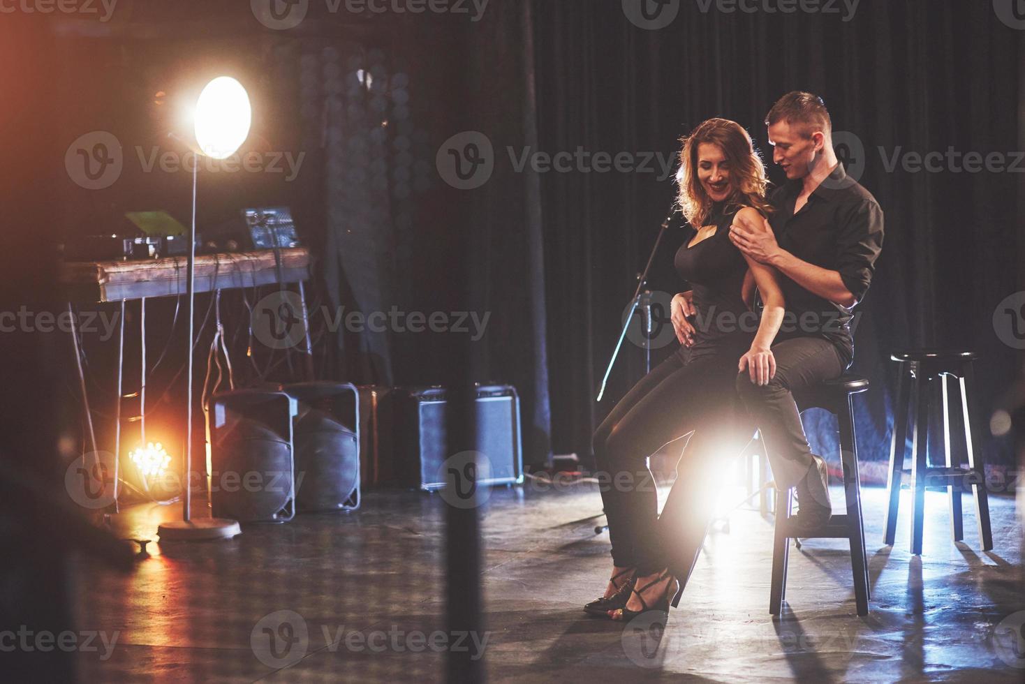 hábiles bailarines actuando en el cuarto oscuro bajo la luz foto