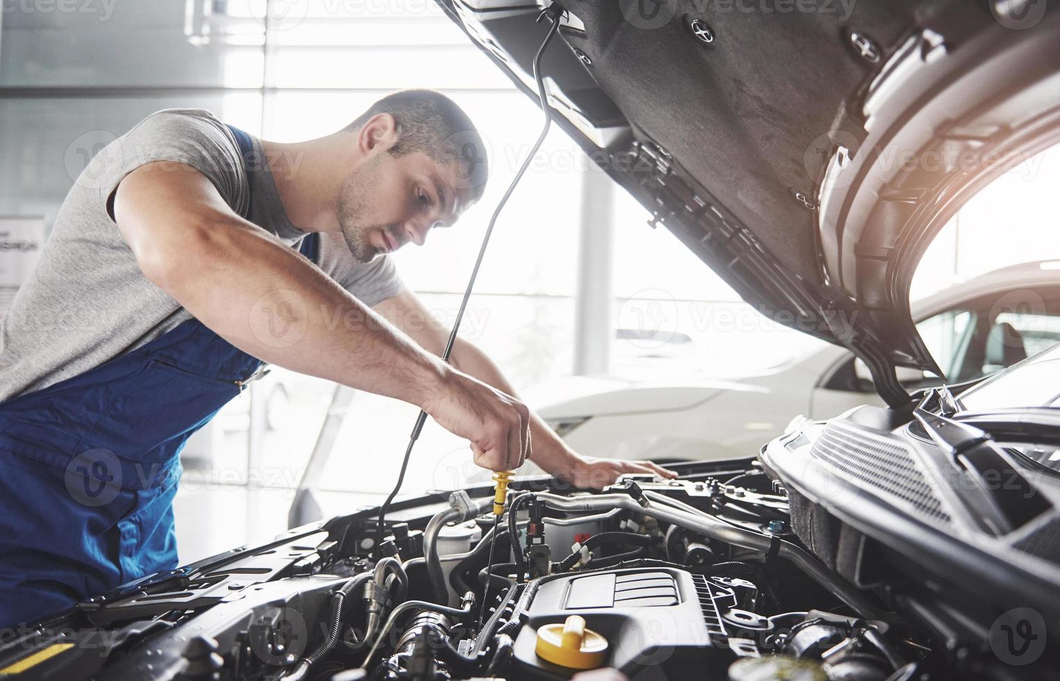 Picture showing muscular car service worker repairing vehicle photo