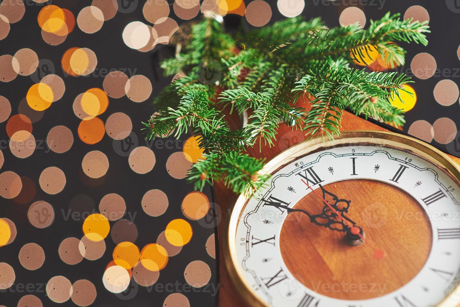 feliz año nuevo a la medianoche de 2018, viejo reloj de madera con luces navideñas y ramas de abeto foto