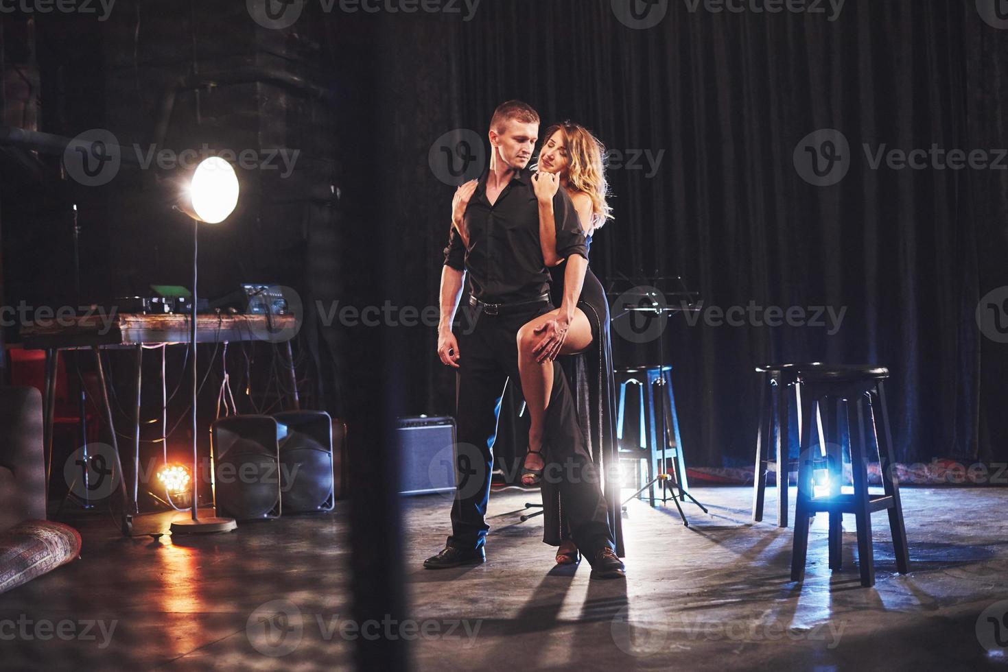 Skillful dancers performing in the dark room under the light photo