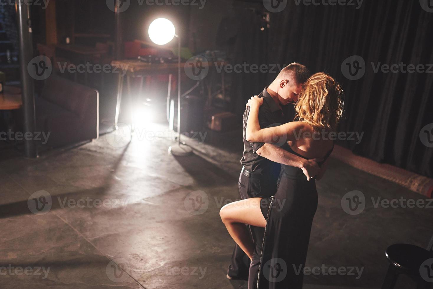 Skillful dancers performing in the dark room under the light photo