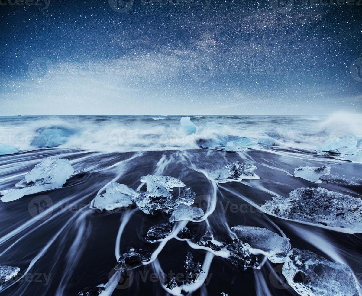 icebergs flotando en el lago glacial jokulsarlon. sur de islandia laguna. noche de cielo estrellado. fantástica vía láctea. foto