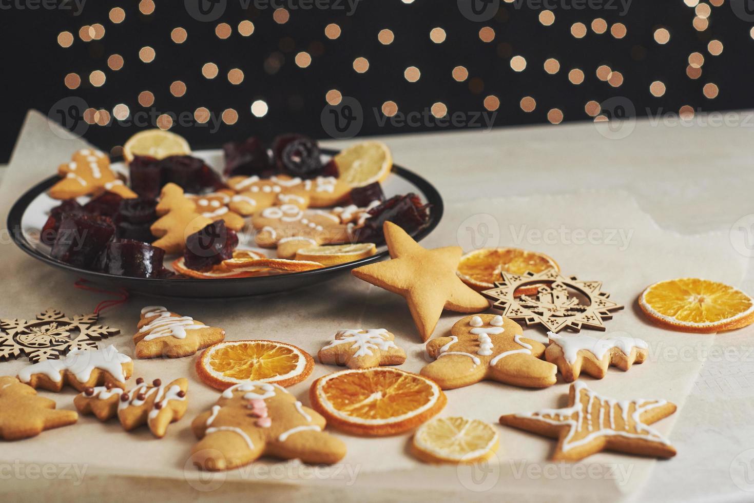 Christmas gingerbread cookies and dried orange and spices on white table. Pastel, jam in rolls on a plate photo