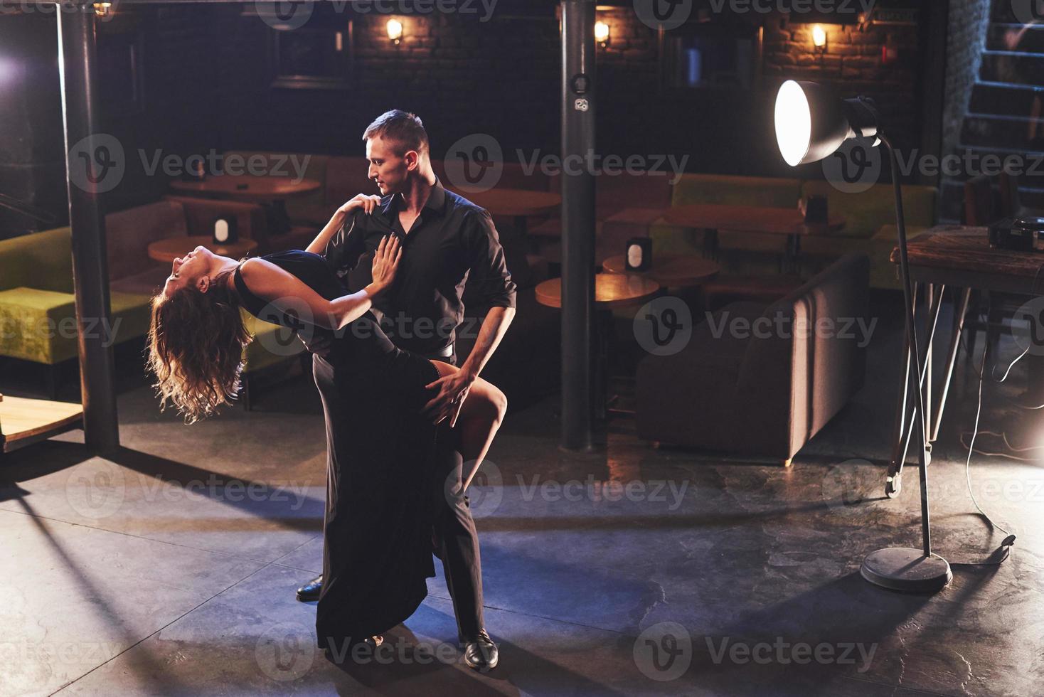 Skillful dancers performing in the dark room under the light photo