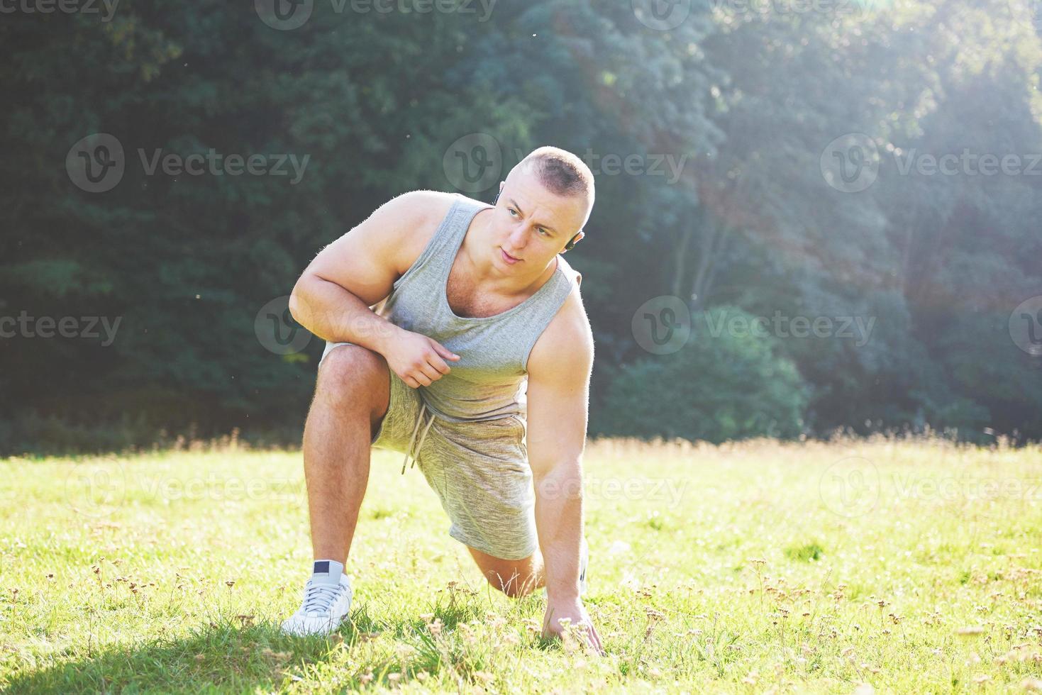 un joven deportista preparándose para el entrenamiento atlético y físico al aire libre. deporte, ejercicio, fitness, entrenamiento. estilo de vida saludable foto