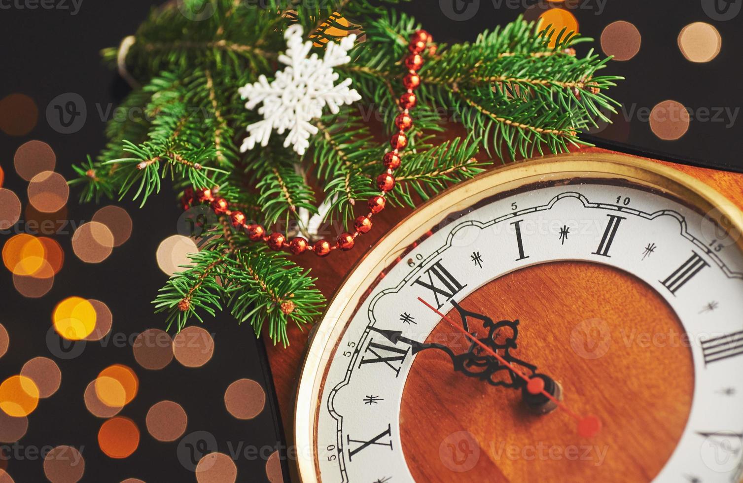 feliz año nuevo a la medianoche de 2018, viejo reloj de madera con luces navideñas y ramas de abeto foto