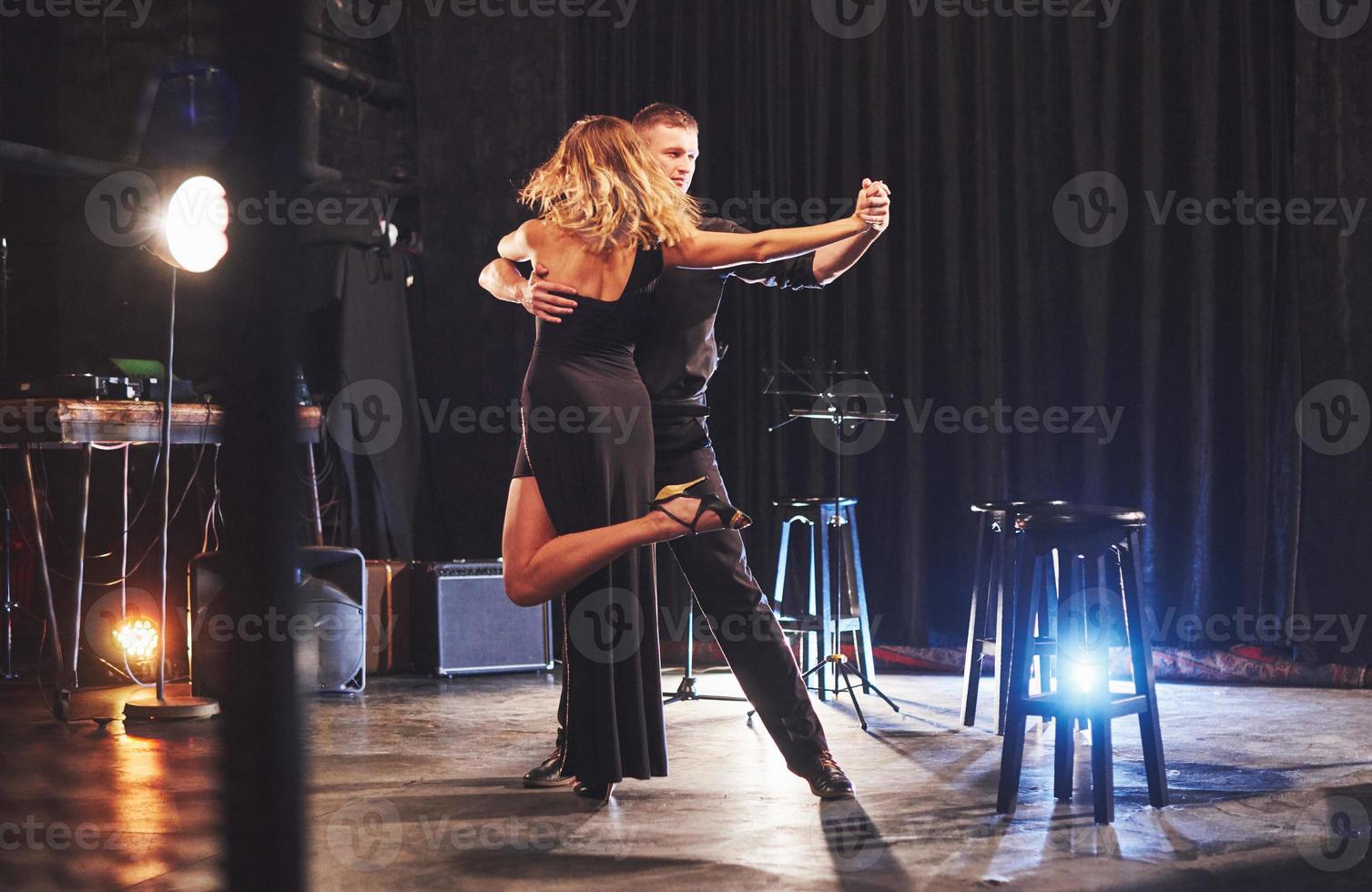 Skillful dancers performing in the dark room under the light photo
