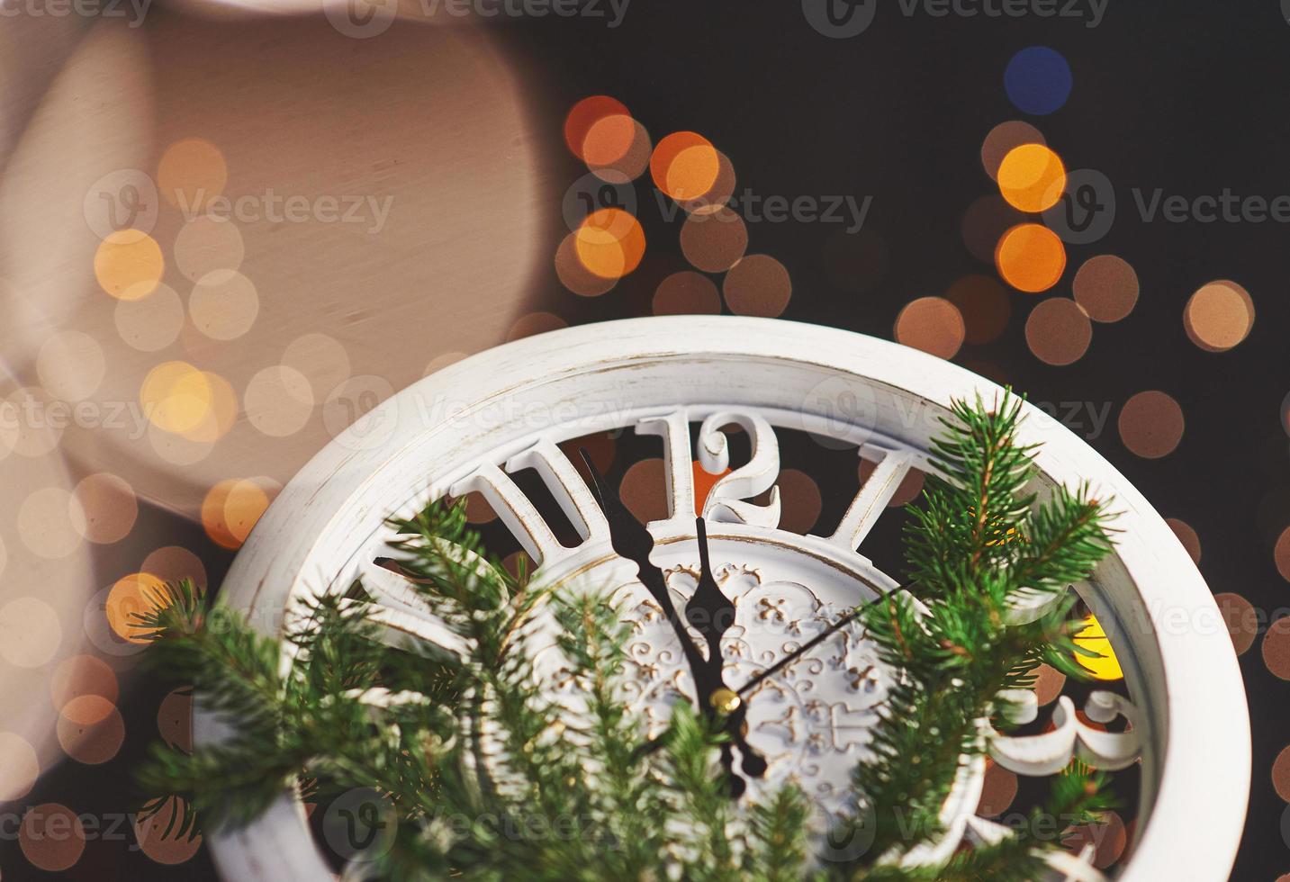 feliz año nuevo a la medianoche de 2018, viejo reloj de madera con luces navideñas y ramas de abeto foto