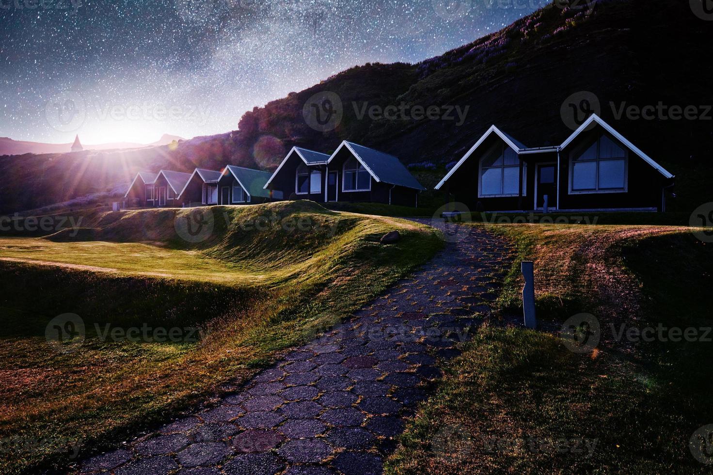 A small wooden church and cemetery Hofskirkja Hof, Skaftafell Iceland. Scenic sunset through tree crowns photo