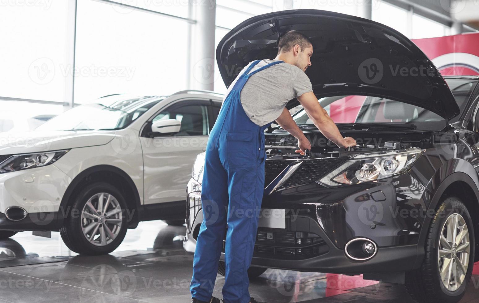 Picture showing muscular car service worker repairing vehicle photo