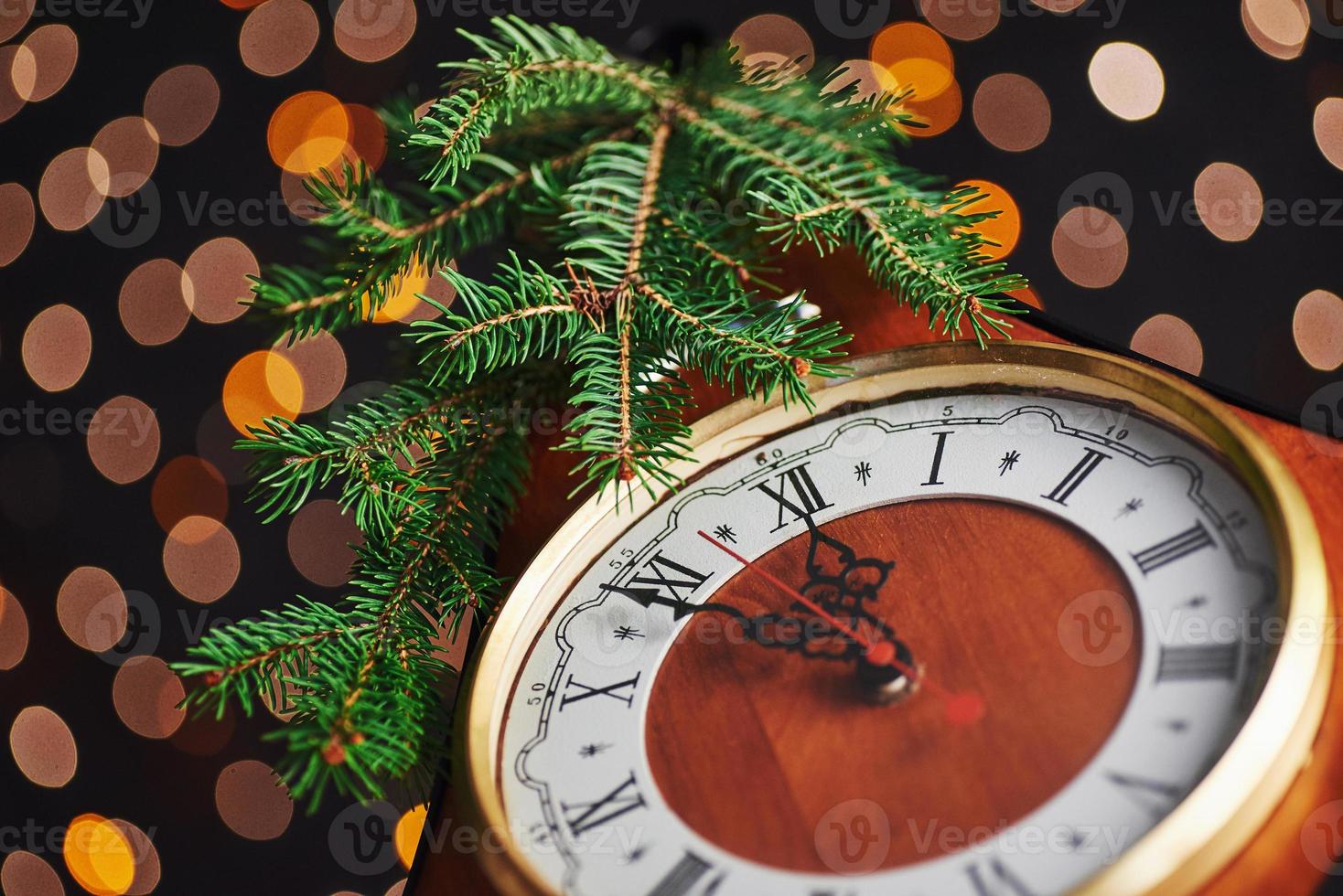 feliz año nuevo a la medianoche de 2018, viejo reloj de madera con luces navideñas y ramas de abeto foto