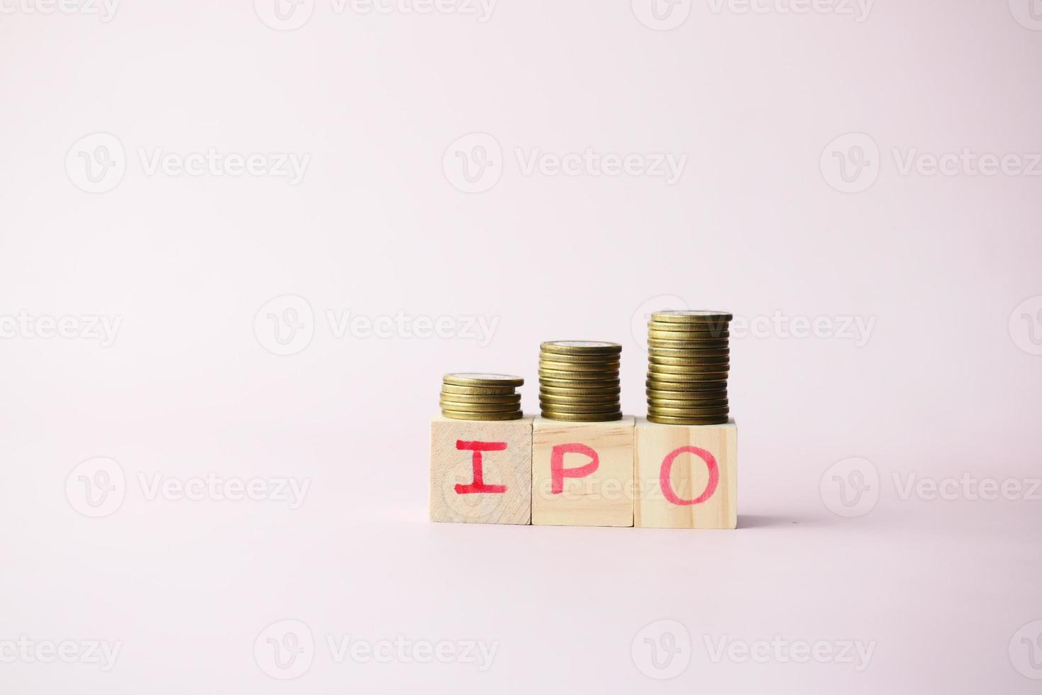 IPO text ,Initial Public Offering on wooden block with stack of coins photo