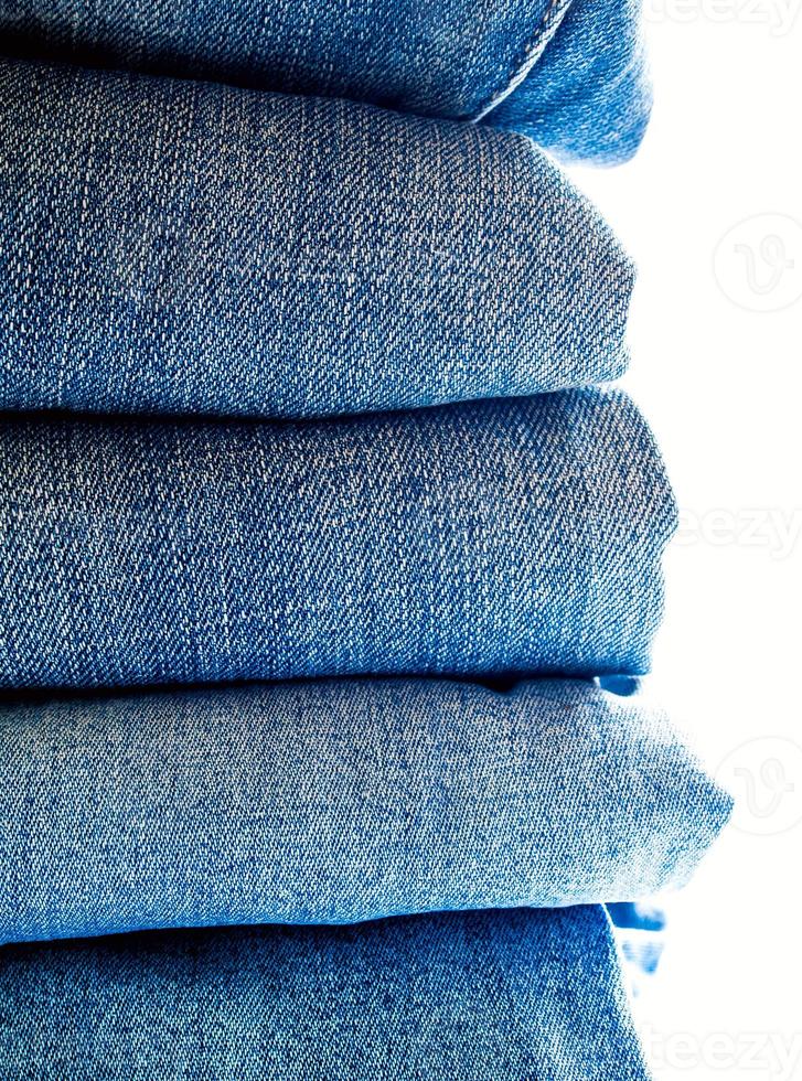 Pile of blue jeans, fabric texture photo