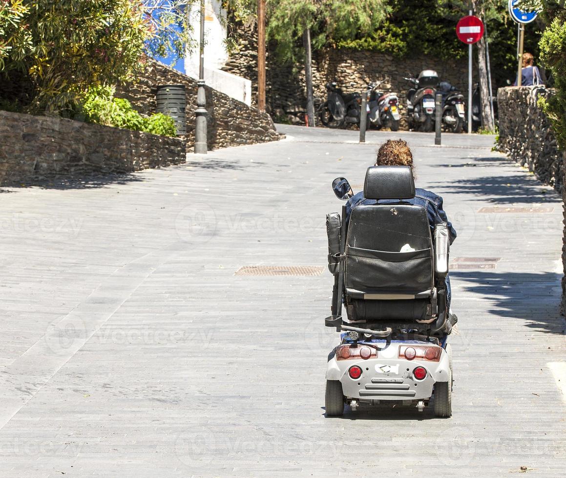 mujer en silla de ruedas eléctrica en la calle foto