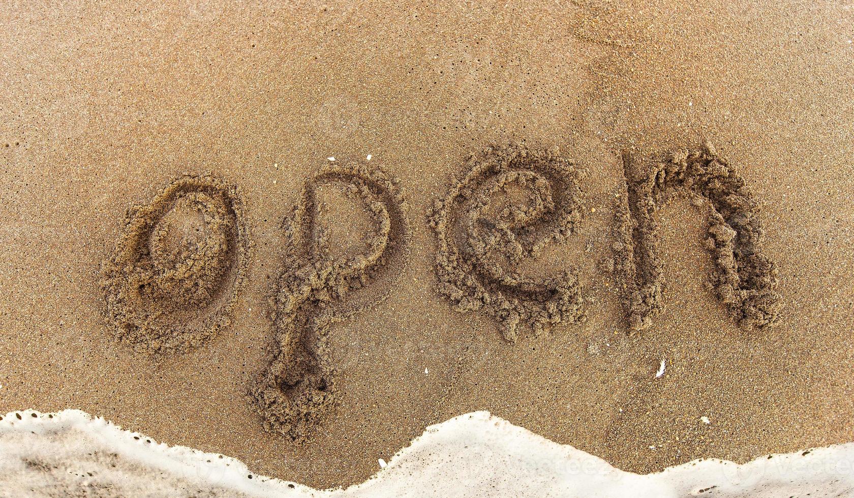 inscription OPEN on the black sand photo
