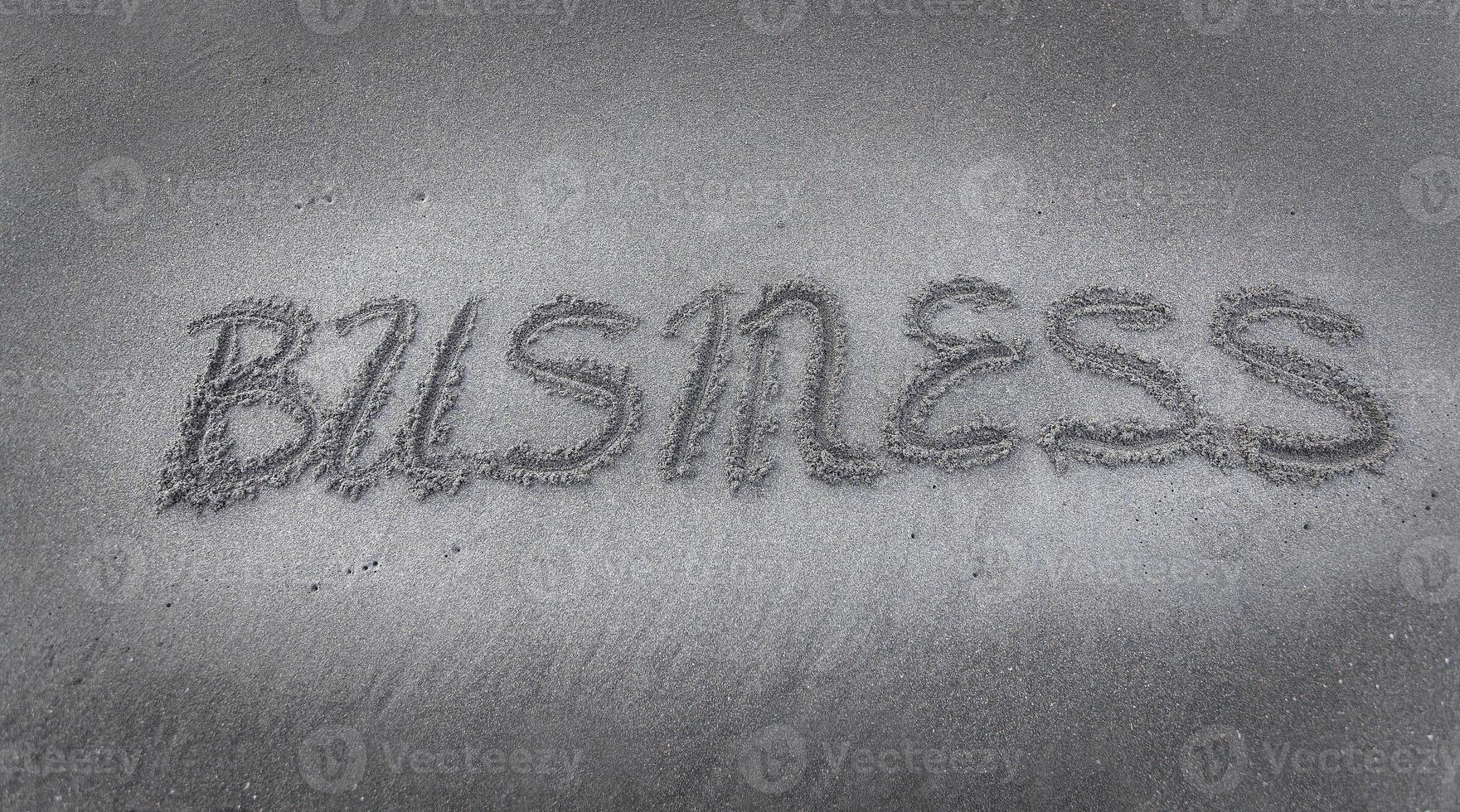 inscription BUSINESS on the black sand photo