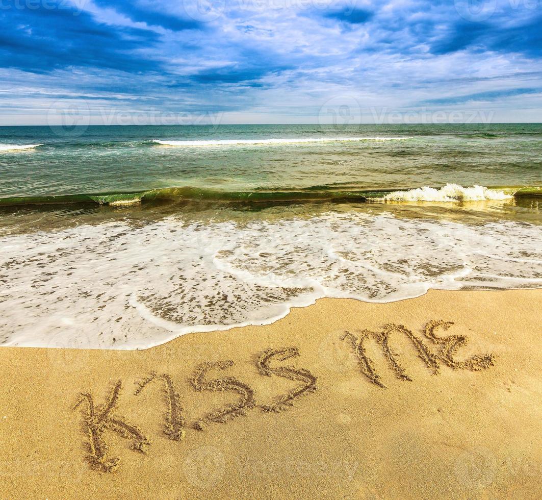 Blue sky and azure ocean with inscription KISS ME on the yellow  sand photo