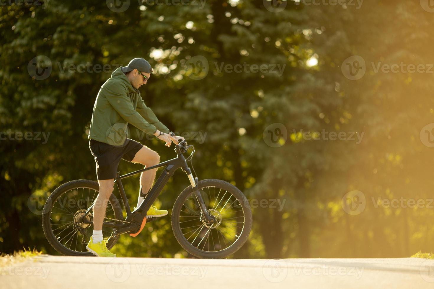 Young man riding ebike in nature photo