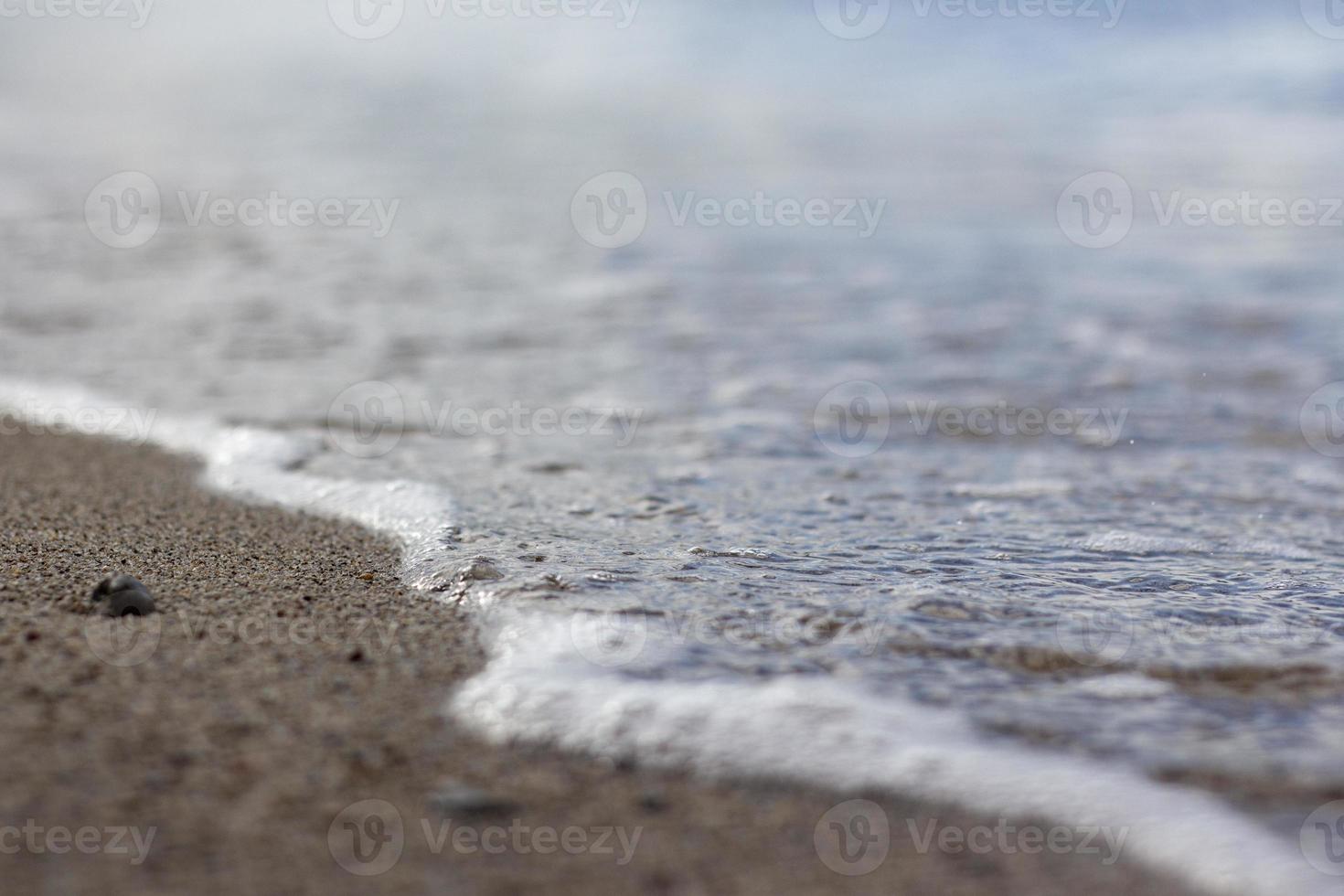 wave splash sea beach macro, close up, Close up of sea foam and wet sand. photo