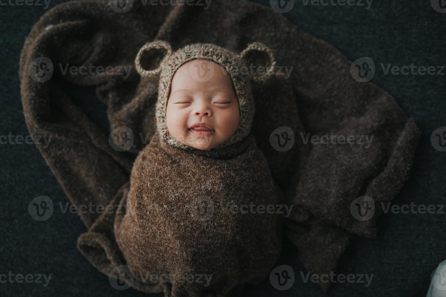 Happy newborn baby wrapped in cocoon photo