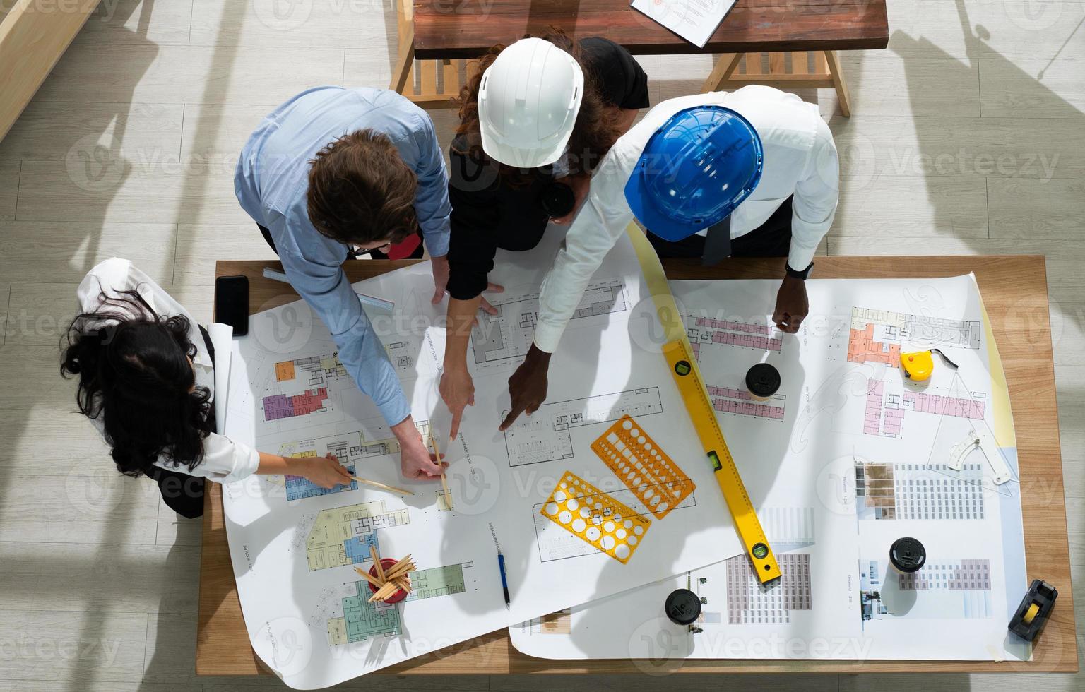 View from Above of Engineer and Architect Discuss About Blue Print in Meeting photo