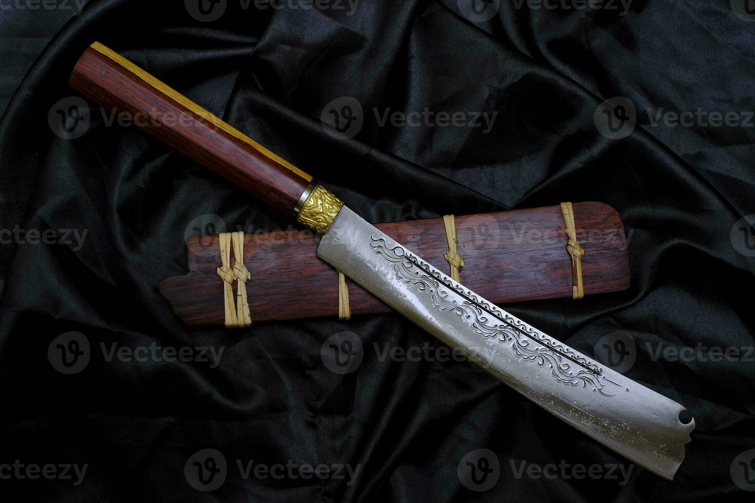 cuchillo personalizado en la carcasa de palisandro natural sobre fondo negro hecho a mano de Tailandia foto