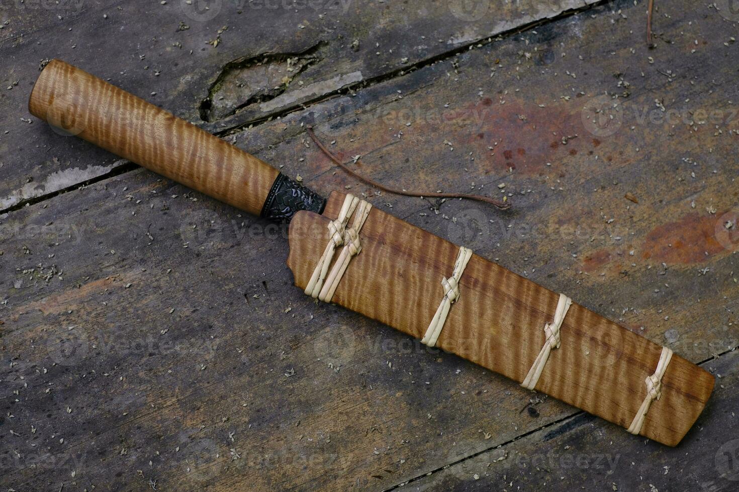 Enep knife custom in the natural Tiger patterned Tabaek wood casing on old table background handmade of Thailand photo