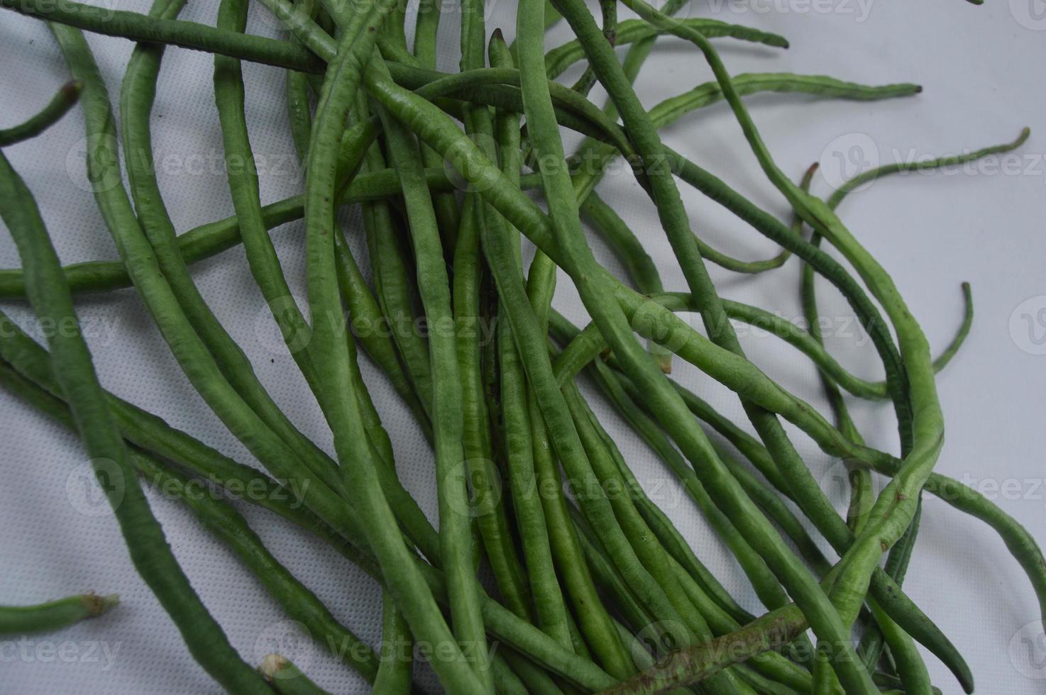 string beans on a white background. food material. source of vitamins. food menu for iftar. photo