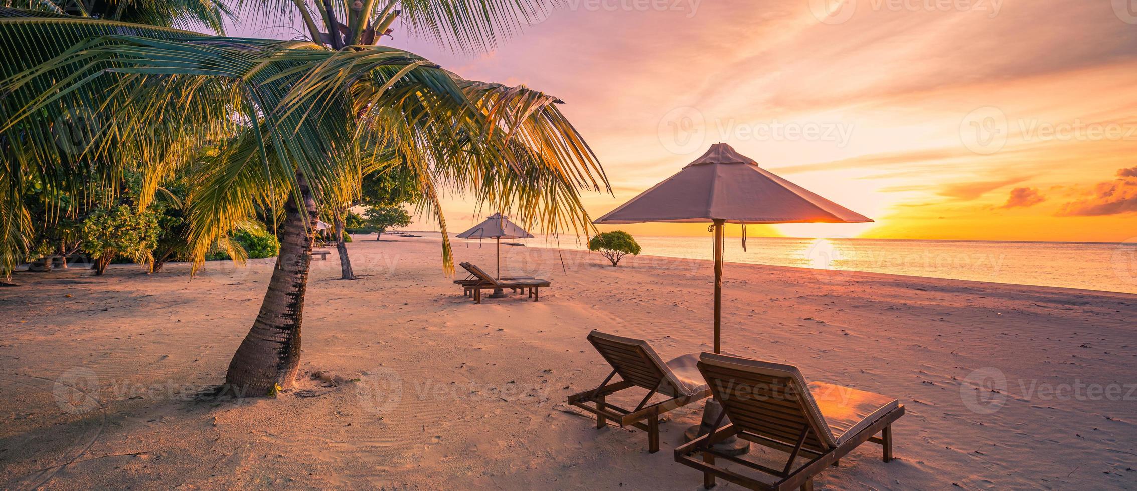 impresionante playa. sombrilla de sillas bajo hojas de palma. vacaciones de verano en la playa, destino de turismo de vacaciones en pareja. paisaje tropical romántico. tranquila playa panorámica, pancarta de paisaje tropical foto