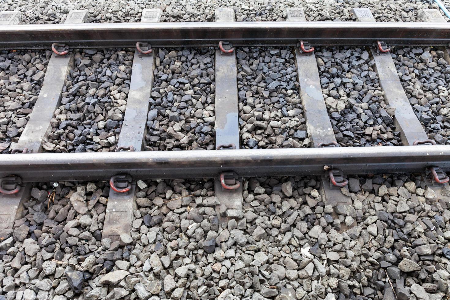 Close up railroad tracks with rust on rock background photo