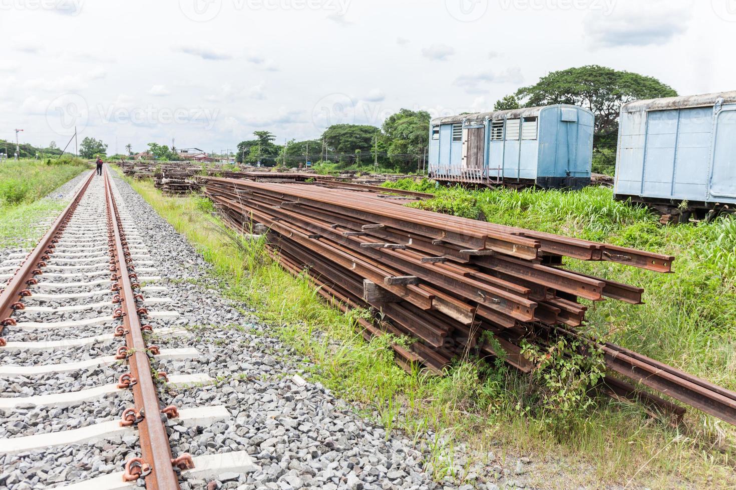 Overview of a railroad track and piles of cross ties lying photo