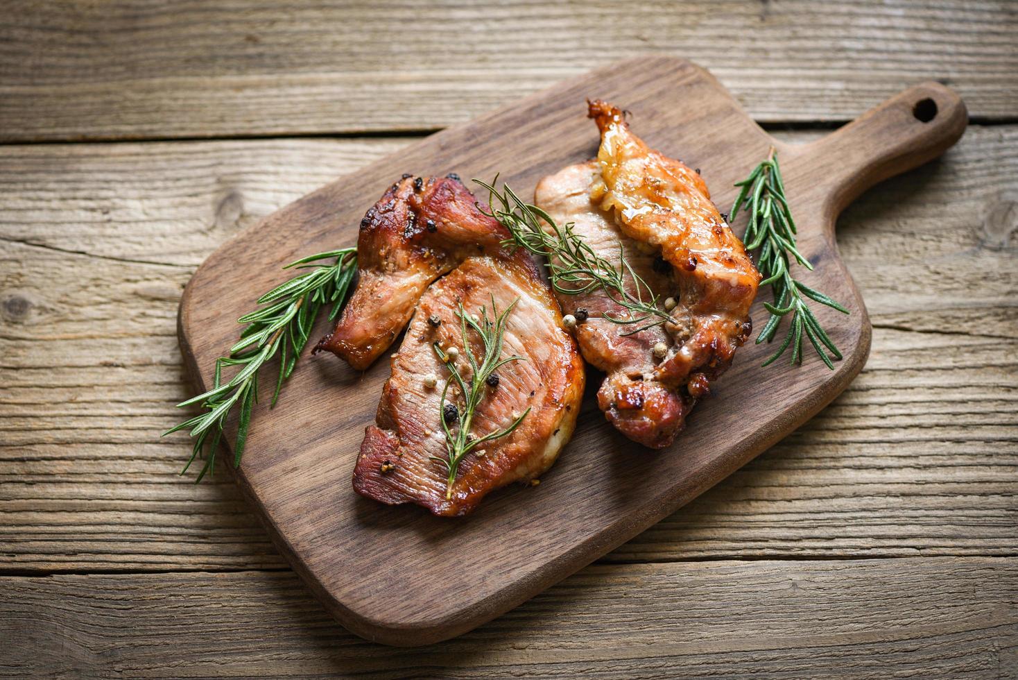 grilled pork meat with sauce and herbs and spices cooking thai asian food rosemary pork on chopping board. photo