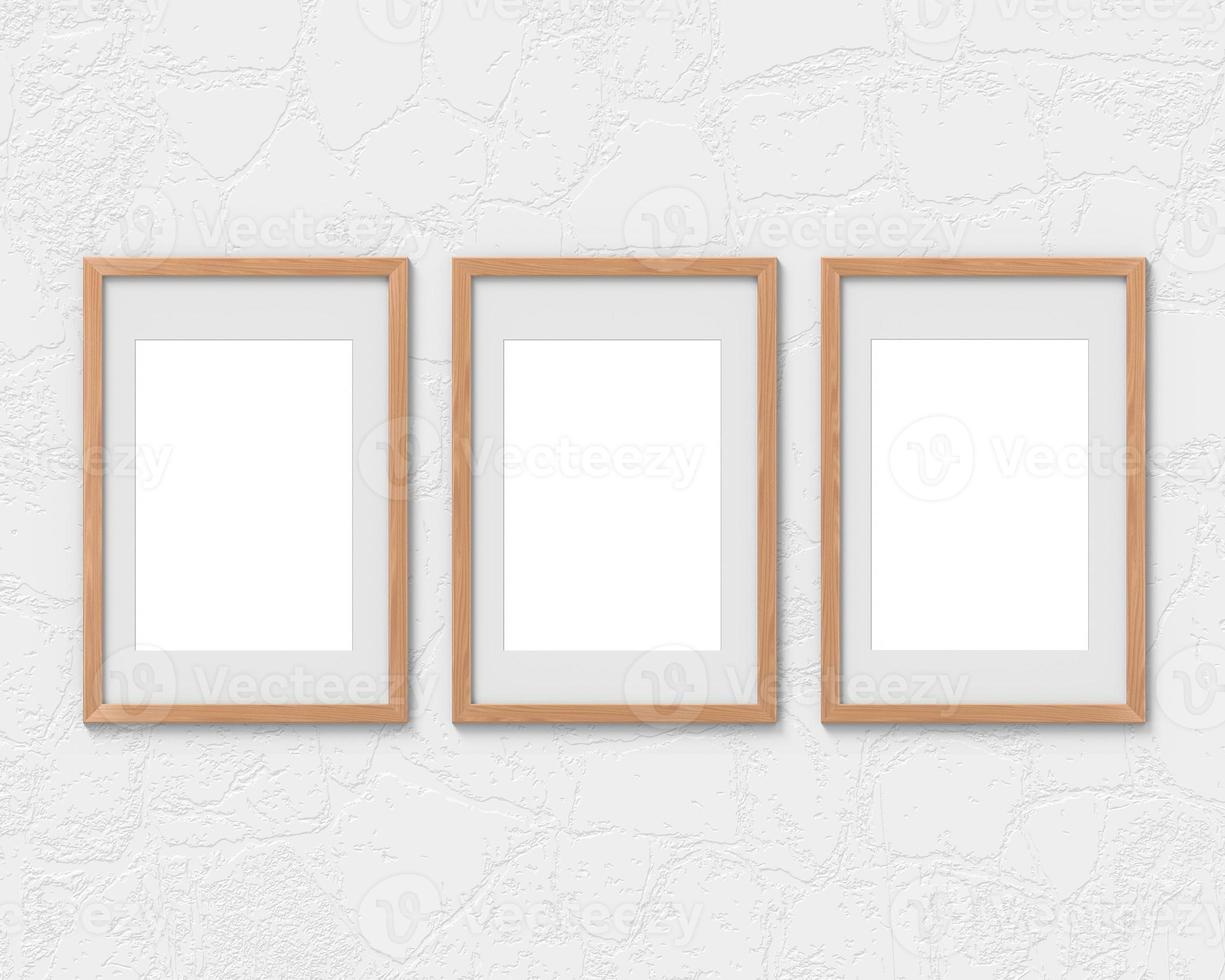 Set of 3 vertical wooden frames mockup with a border hanging on the wall. Empty base for picture or text. 3D rendering. photo