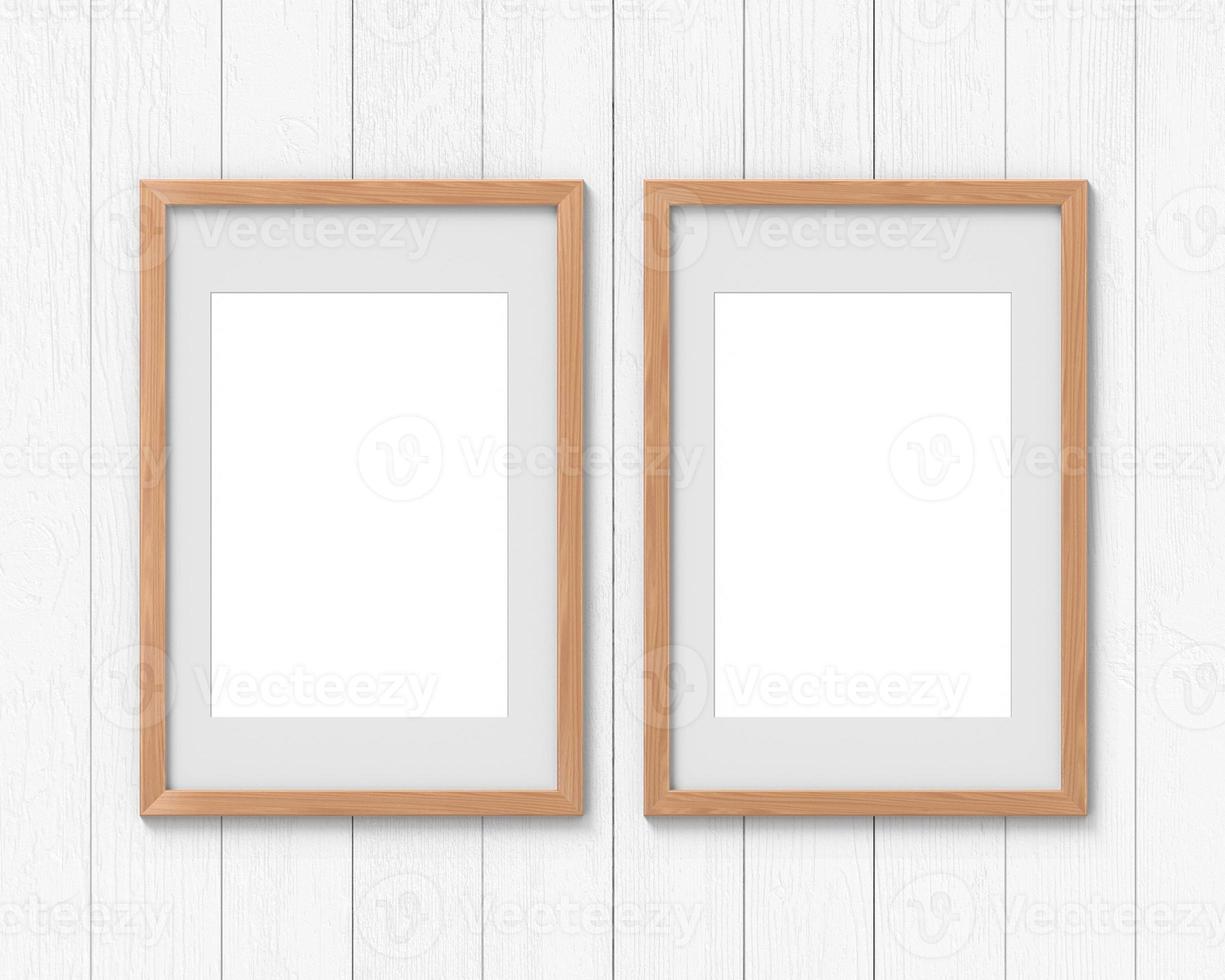 conjunto de 2 maquetas de marcos de madera verticales con un borde colgado en la pared. base vacía para imagen o texto. representación 3d foto