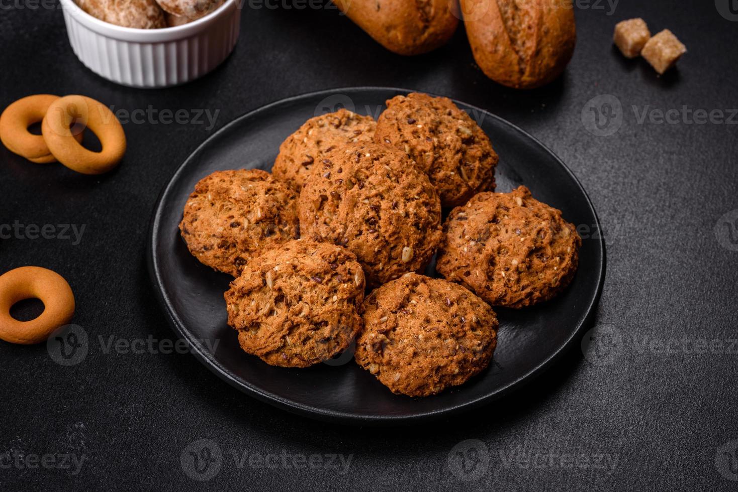 Tasty fresh oat cookies on a dark concrete background photo