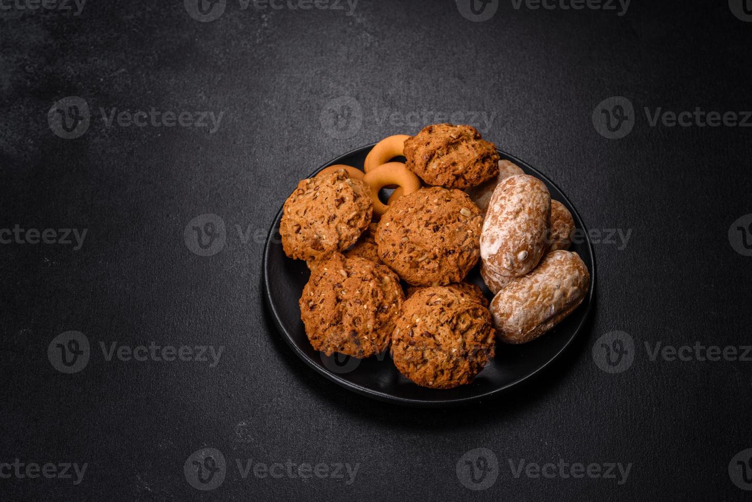 Tasty fresh oat cookies on a dark concrete background photo