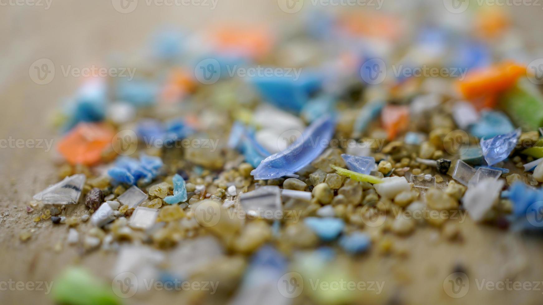 Macro shot of authentic real microplastic particles gathered from the beach with a ruler to show their size. Water pollution and global warming concept. photo