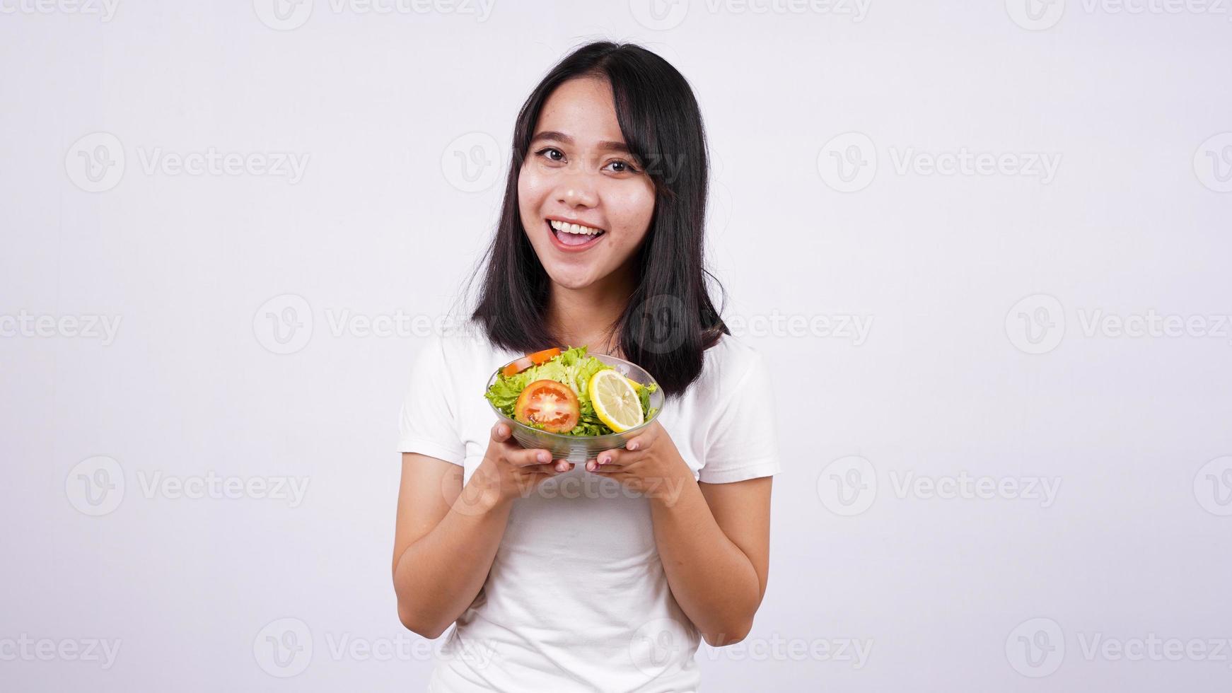 joven mujer asiática ensalada feliz y saludable con fondo blanco aislado foto