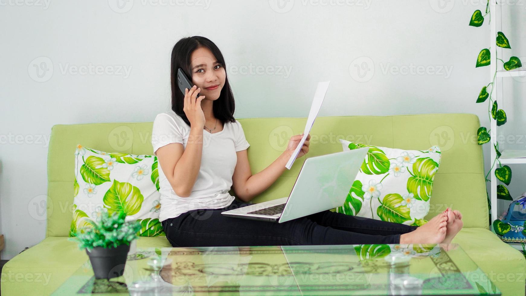 hermosas mujeres asiáticas que trabajan desde casa usando una computadora portátil y llamando por teléfono foto