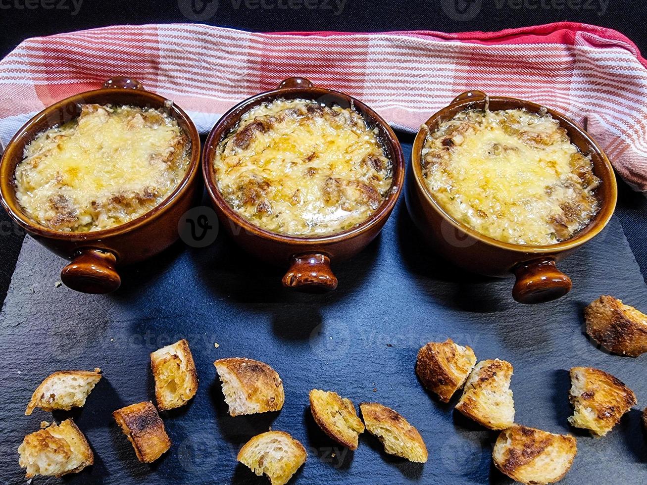 Fresh French onion soup with coutons and cheese topping photo