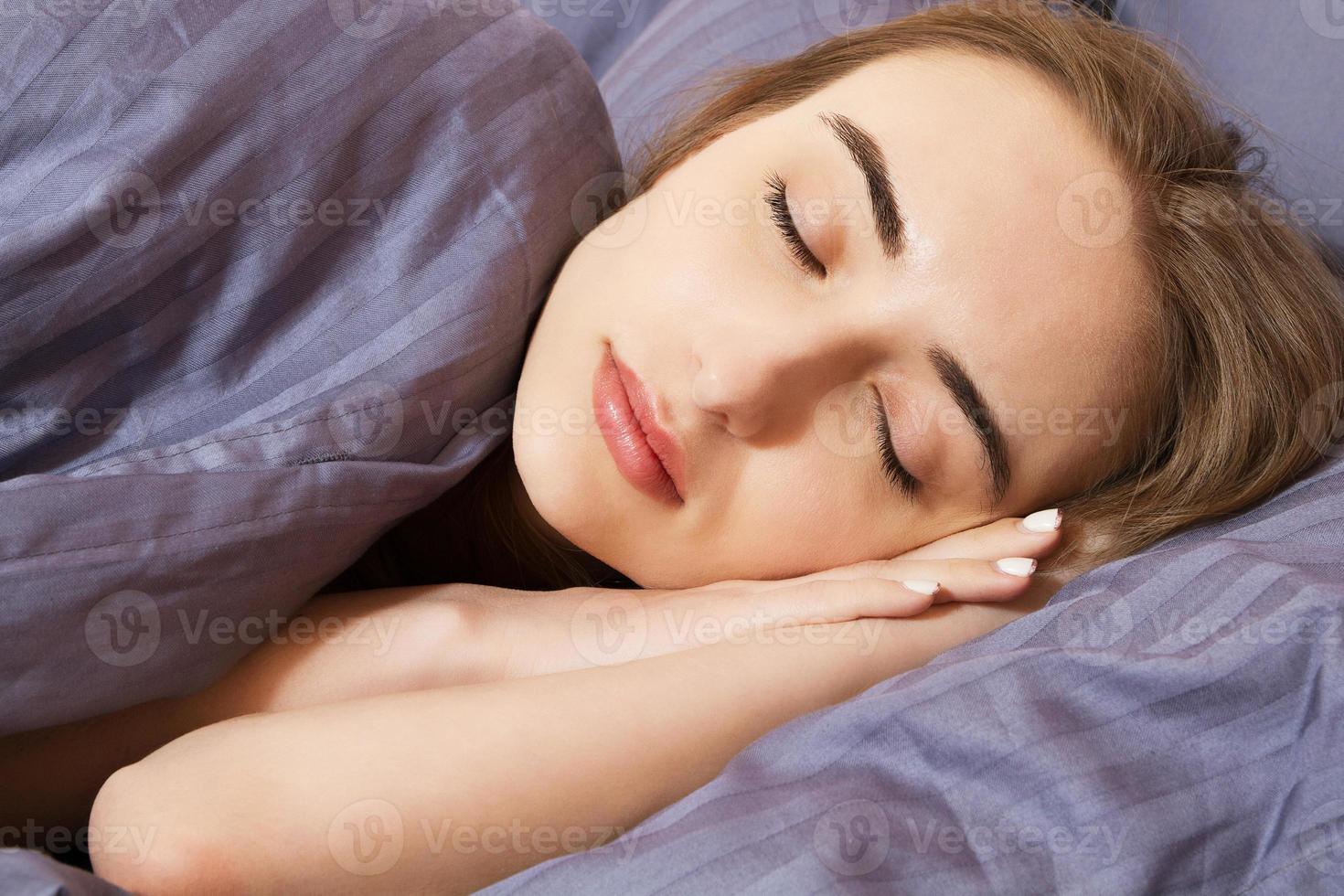 Portrait of a young woman sleeping on the bed at home Closeup photo