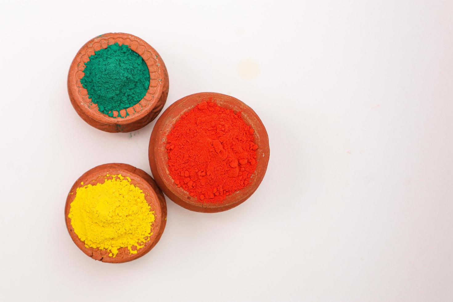 Indian festival Holi concept  bowl with colors of holi on white background. photo