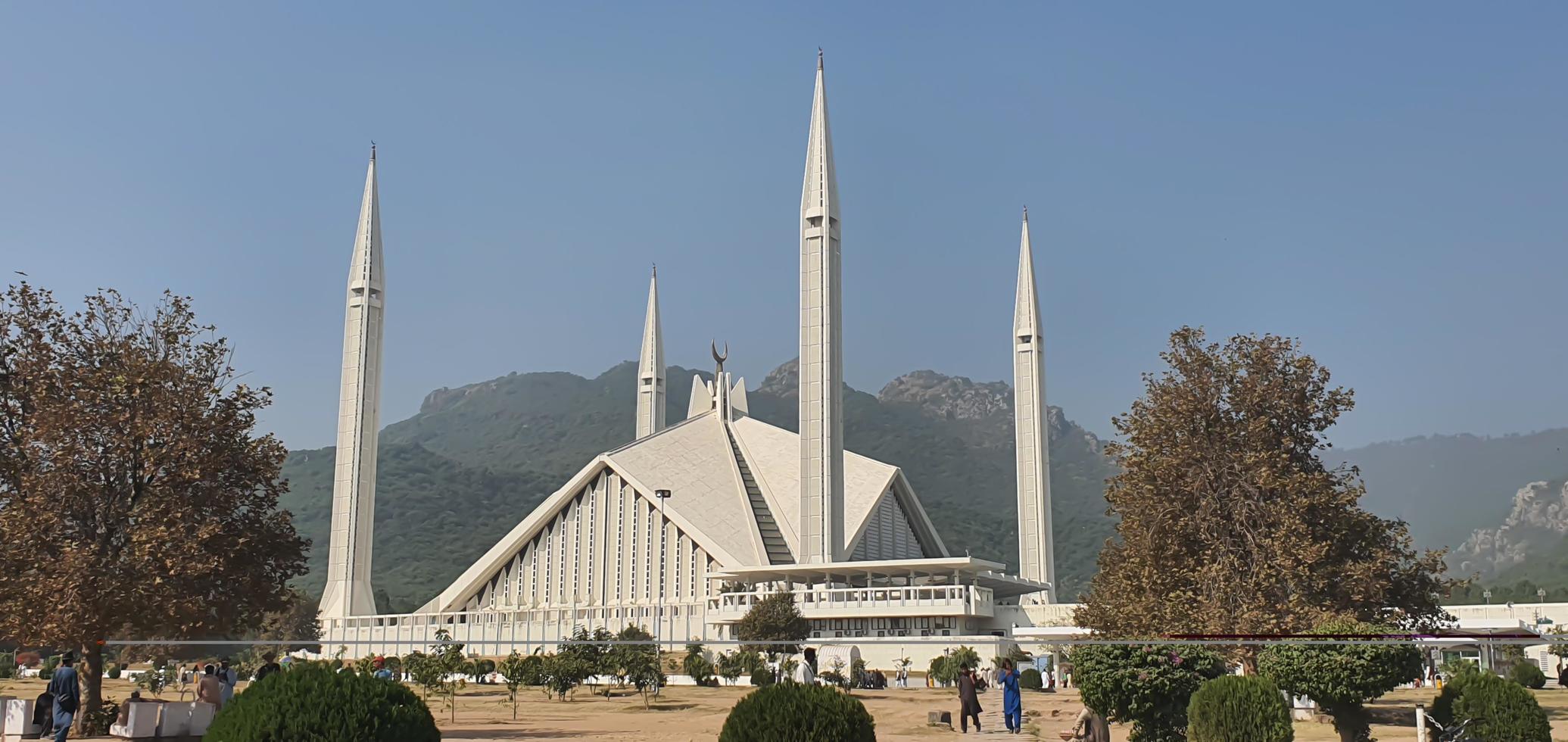 islamabad, punjab, pakistán, 2022, mezquita faisal en la ciudad de islamabad con montaña verde y plantas foto